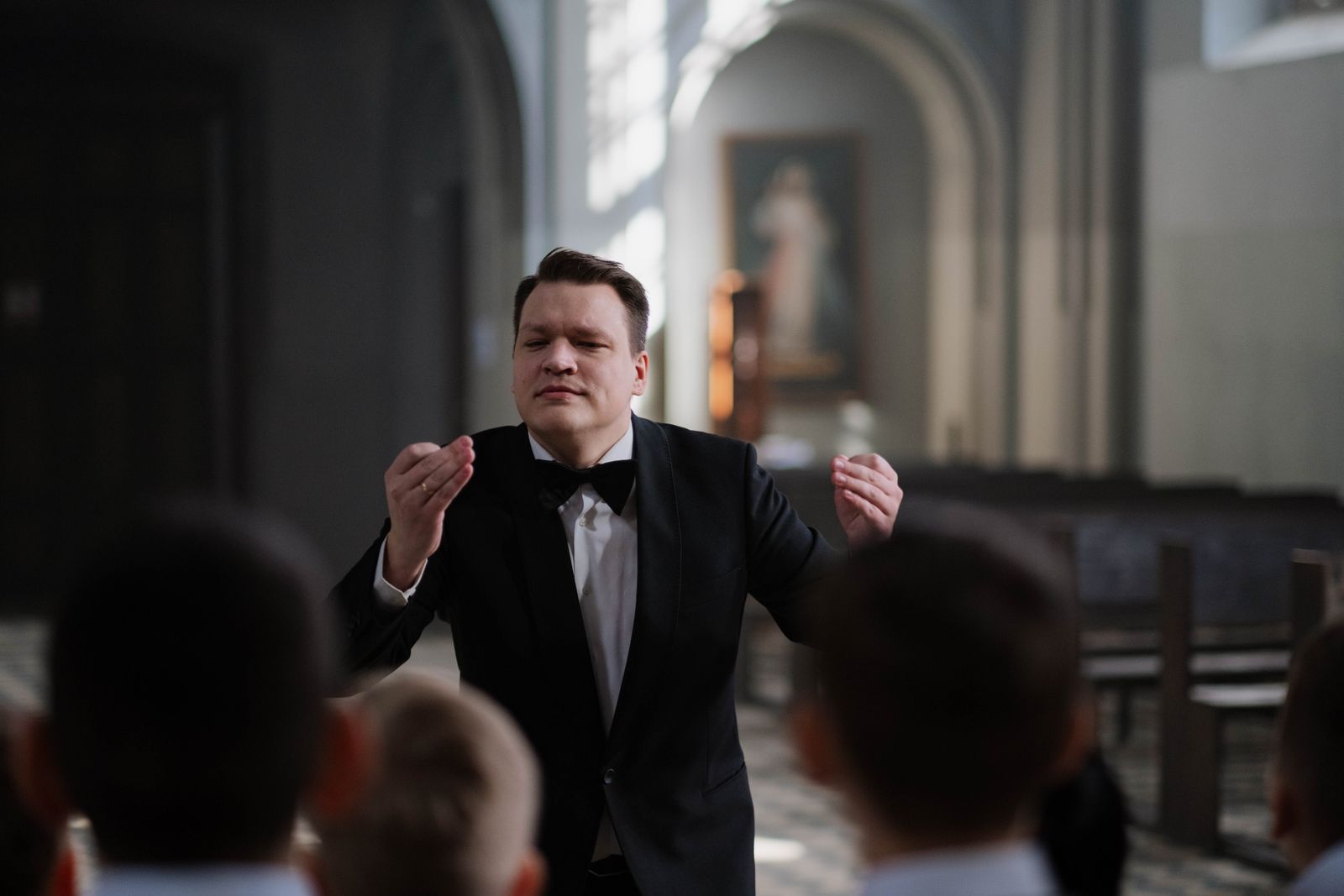 Dirigent leitet das Orchester mit ausdrucksstarker Handbewegung